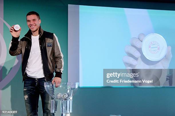 Lukas Podolski of FC Koeln smiles with the Bayern Muenchen logo drawing the Women's DFB Cup round of sixteen matches during the DFB press conference...