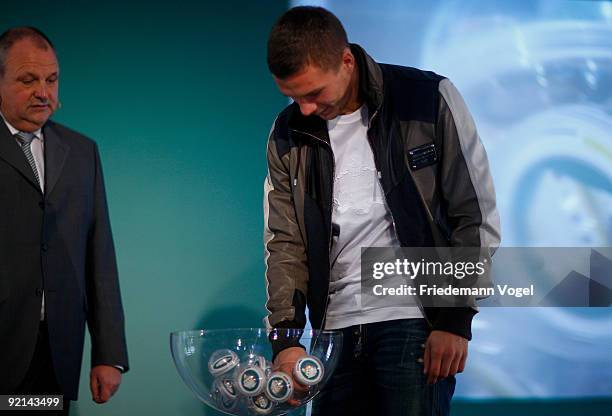 Spokesman Harald Stenger and Lukas Podolski of FC Koeln draws the next womens soccer cup round of sixteen during the DFB press conference for the...