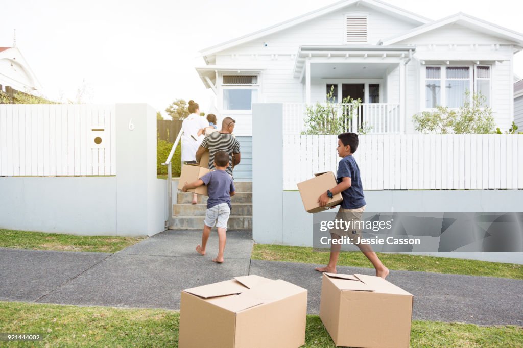 Family move boxes into their new home