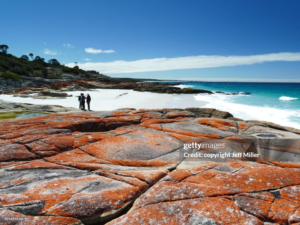 Group standing on beach near granite outcrop, Bay of Fires, Tasmania