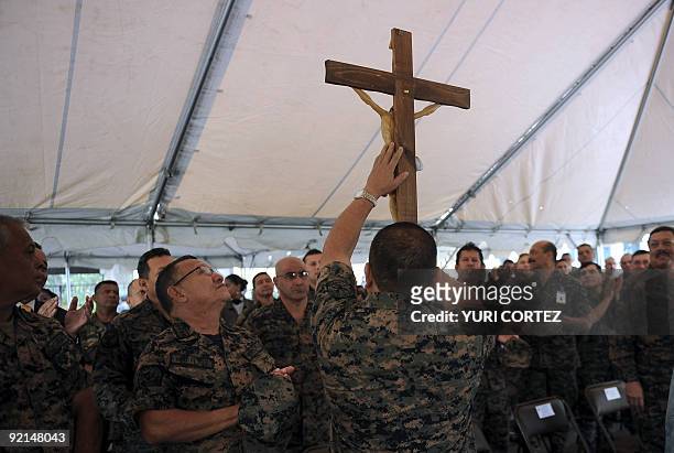 The Chief of the Honduran Armed Forces, General Romeo Vasquez, shows a crucifix to soldiers during a mass to celebrate Army Day on October 21, 2009...
