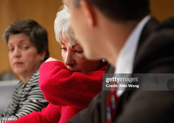 Secretary of Health and Human Services Kathleen Sebelius coughes onto her sleeve as Homeland Security Secretary Janet Napolitano and Education...