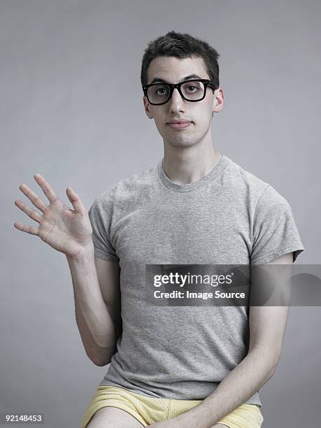 young man waving - gray shorts stock-fotos und bilder