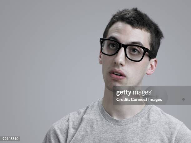 young man wearing glasses - visage sans expression photos et images de collection