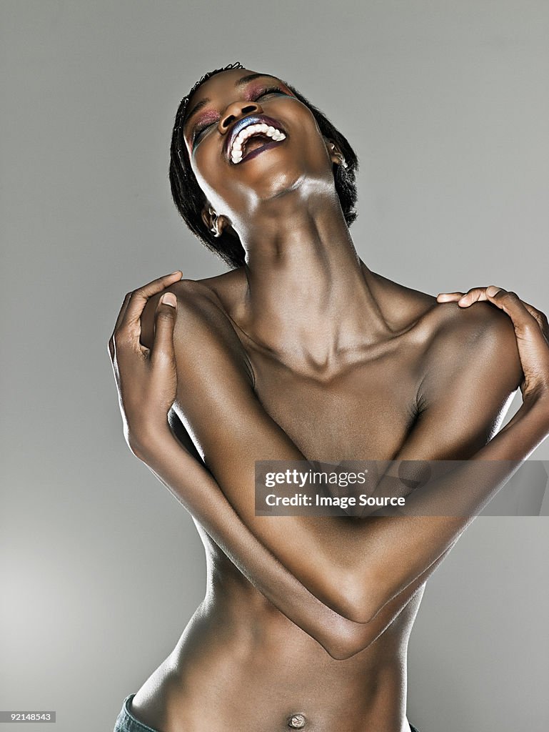 Happy young woman with arms over chest