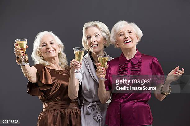 senior female friends toasting with champagne - glamour bildbanksfoton och bilder