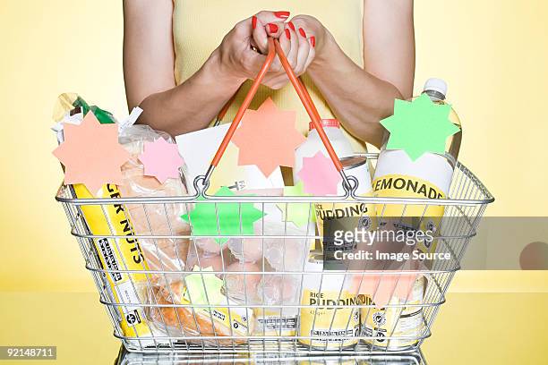woman with basic groceries in basket - poverty reduction stock-fotos und bilder