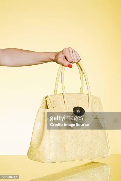 woman holding yellow handbag - handtasche stock-fotos und bilder