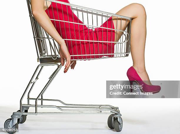 woman in a shopping trolley - einkaufswagen freisteller stock-fotos und bilder