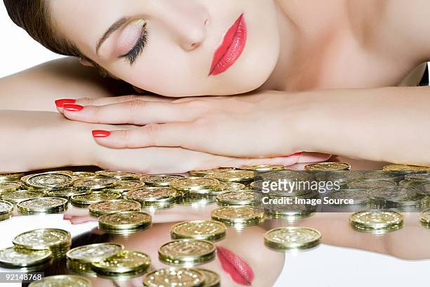 coins and woman woman with eyes closed - gold nail polish stock-fotos und bilder