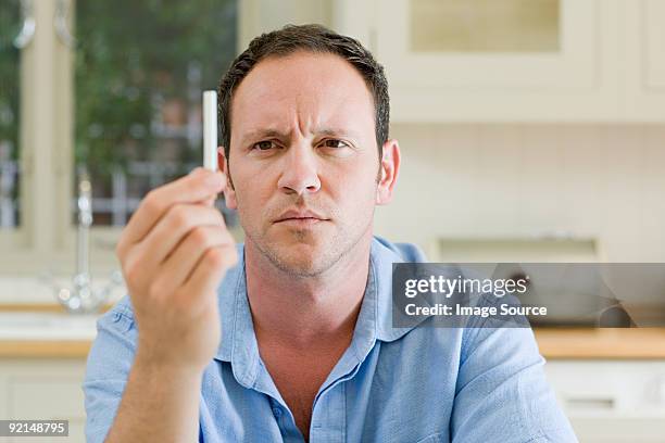 mann, blick in zigarette - rauchen aufhören stock-fotos und bilder