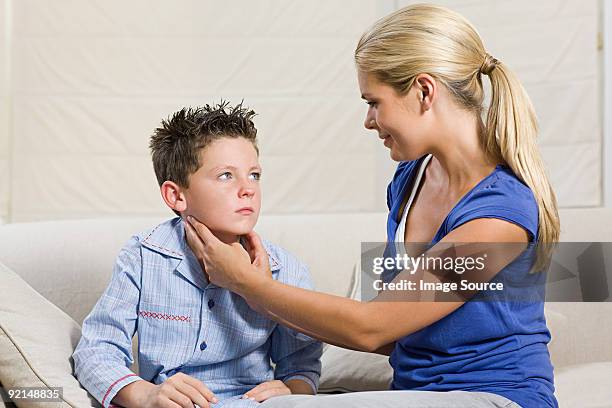mother feeling feeling sons neck - infectious mononucleosis stock pictures, royalty-free photos & images