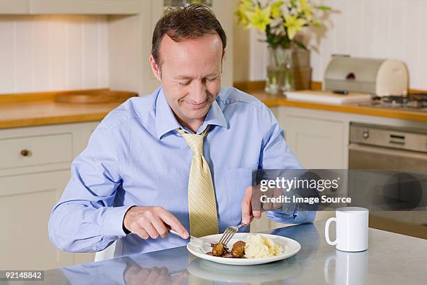 hombre comiendo una comida - carne procesada fotografías e imágenes de stock