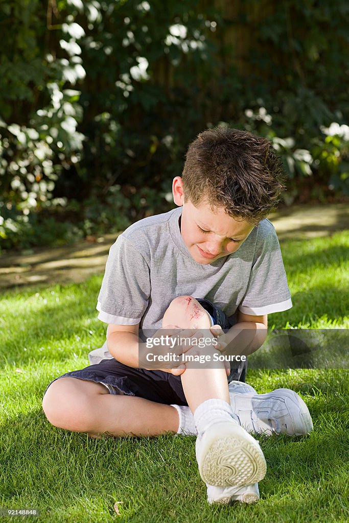 Niño con grazed de la rodilla