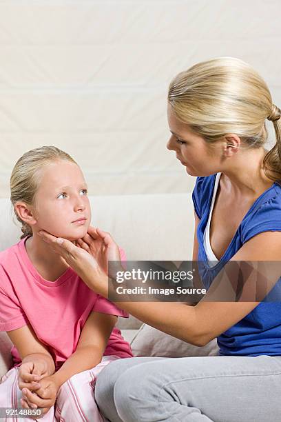 mother feeling feeling daughters neck - paramyxovirus stock pictures, royalty-free photos & images