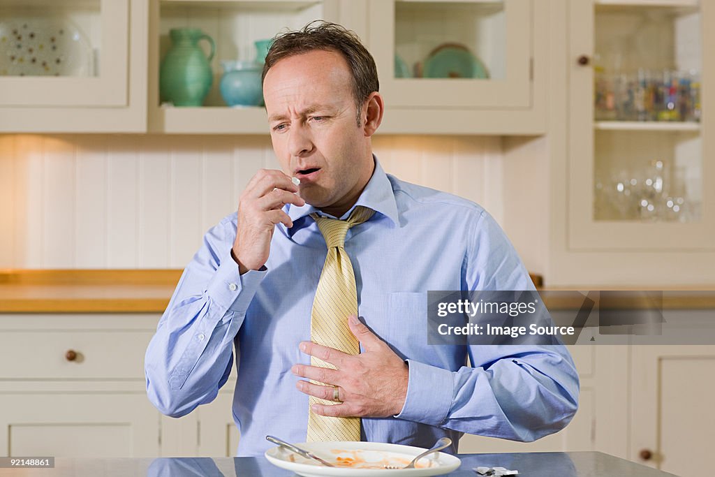 Hombre tomando indigestión comprimido