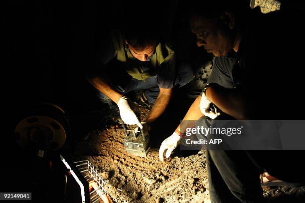 Bangladeshi bomb squad police officers collect evidence at the scene of a bomb blast in Dhaka on October 21, 2009. At least 10 people were injured...