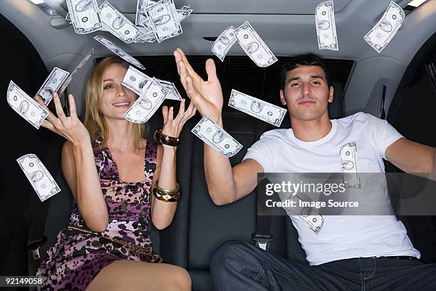 wealthy couple celebrating in a car - throwing money stock pictures, royalty-free photos & images