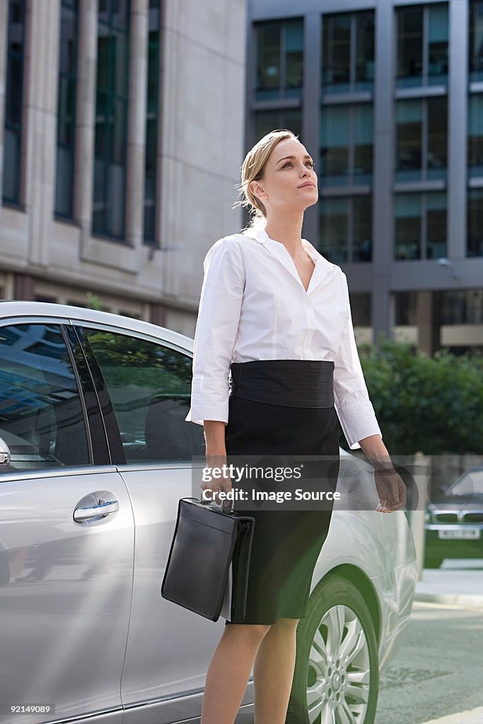 Businesswoman standing by car