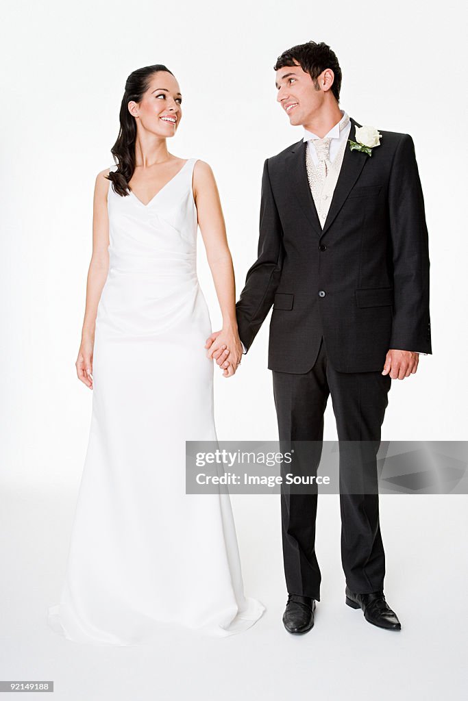 Newlywed couple holding hands