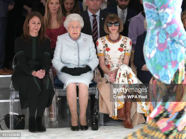 Queen Elizabeth II sits next to Anna Wintour and Caroline Rush, chief executive of the British Fashion Council as they view Richard Quinn's runway...