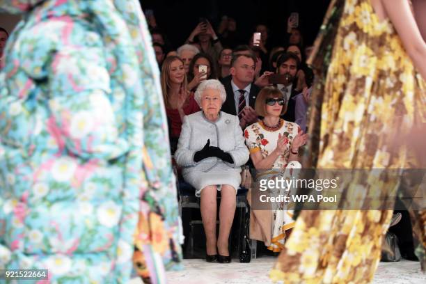Queen Elizabeth II sits next to Anna Wintour as they view Richard Quinn's runway show before presenting him with the inaugural Queen Elizabeth II...