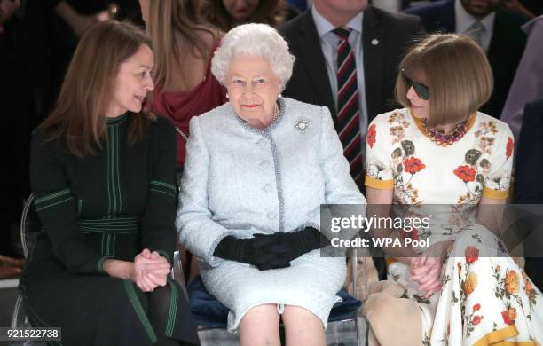 Queen Elizabeth II sits next to Anna Wintour and Caroline Rush, chief executive of the British Fashion Council as they view Richard Quinn's runway...