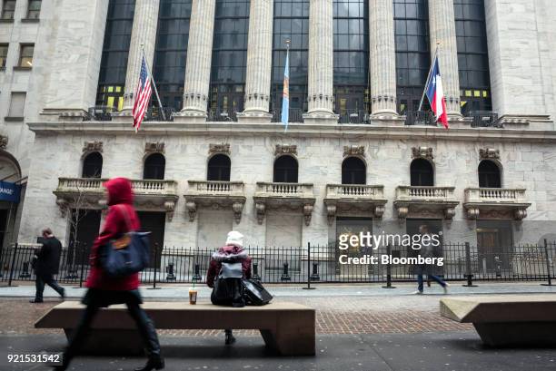 Pedestrians pass in front of the New York Stock Exchange in New York, U.S., on Tuesday, Feb. 20, 2018. Treasuries fell, with investors driving the...