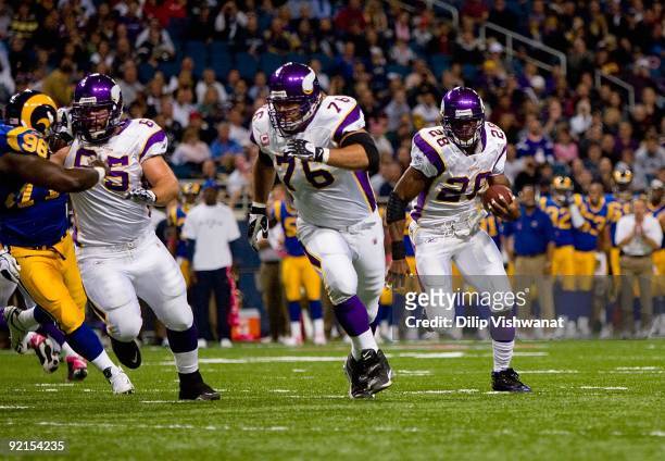 Adrian Peterson of the Minnesota Vikings runs to his left toward the end zone in front of teammates Steve Hutchinson and John Sullivan during their...