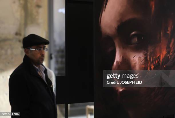 People visit the exhibition "Haneen, a Collective Work of Lebanese and Syrian artists on the impact of war on childhood", in Beirut on February 20,...