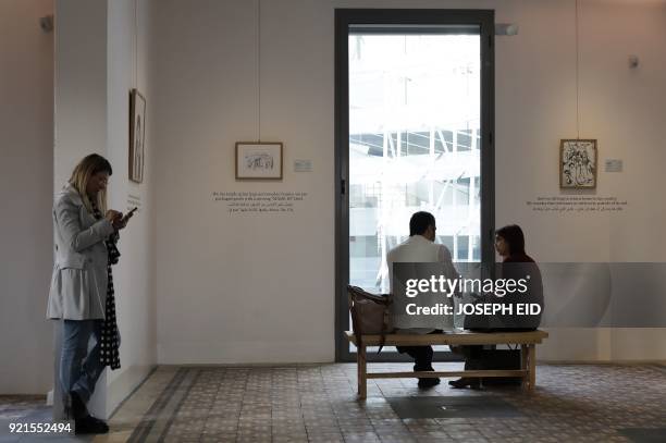 People visit the exhibition "Haneen, a Collective Work of Lebanese and Syrian artists on the impact of war on childhood", in Beirut on February 20,...