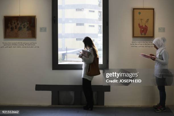 People visit the exhibition "Haneen, a Collective Work of Lebanese and Syrian artists on the impact of war on childhood", in Beirut on February 20,...