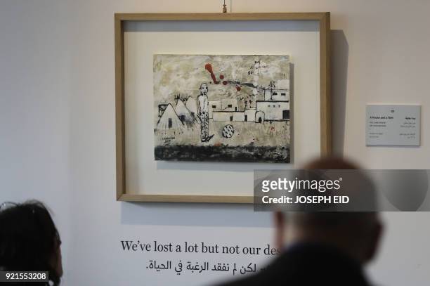 People visit the exhibition "Haneen, a Collective Work of Lebanese and Syrian artists on the impact of war on childhood", in Beirut on February 20,...