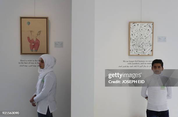 Syrian refugee children stand by the artworks inspired from their poems at the exhibition "Haneen, a Collective Work of Lebanese and Syrian artists...