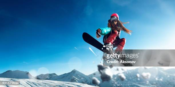 weibliche extreme freestyle-snowboarder springen - big air stock-fotos und bilder