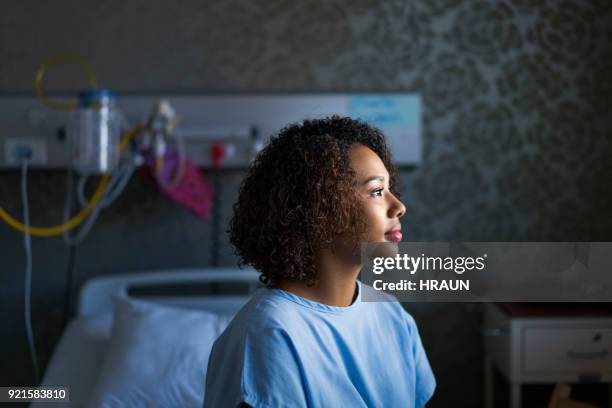 side view of female patient sitting at hospital - one young woman only health hopeful stock pictures, royalty-free photos & images