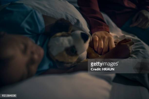 moeder bezit is van de hand van de jongen op bed slapen - child hospital bed stockfoto's en -beelden