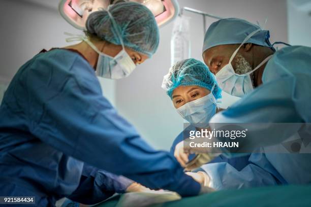 multi-ethnischen ärzte operative mädchen im krankenhaus - chirurgenkappe stock-fotos und bilder