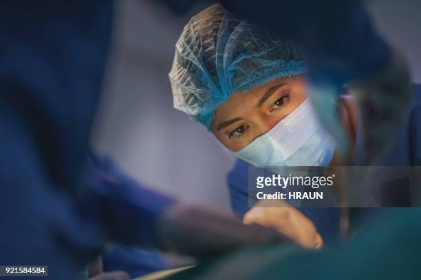 cirurgiões realizar cirurgia no hospital - female surgeon mask - fotografias e filmes do acervo