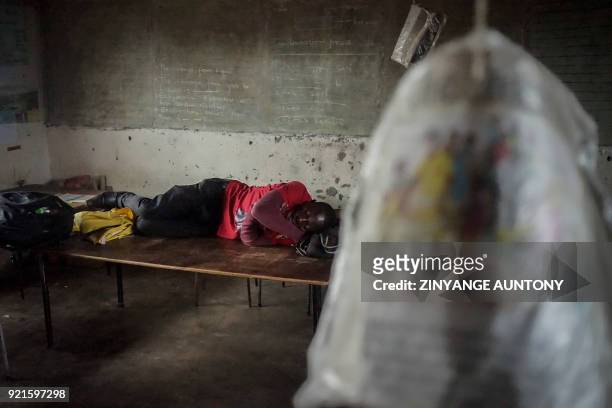 Supporter of the opposition Movement for Democratic Change sleeps in a classroom at Makanda Primary School as he awaits the burial of late leader...