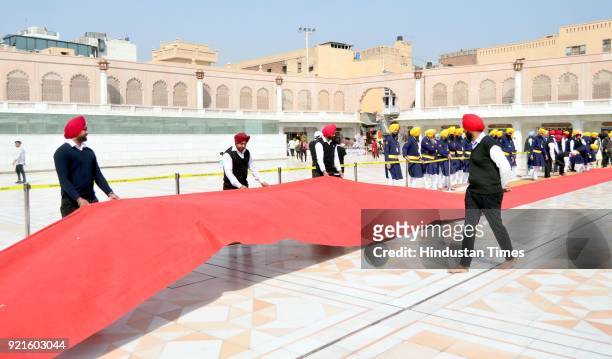 Cops adjusts Red Carpet outside Golden Temple during rehearsal on the eve of visit of Canadian Prime Minister Justin Trudeau on February 20, 2018 in...