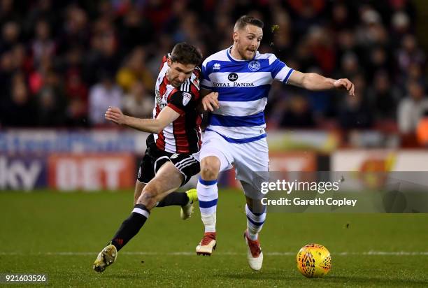 Conor Washington of Queens Park Rangers is challenged by Chris Basham of Sheffield United during the Sky Bet Championship match between Sheffield...