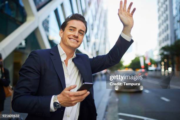 hailing a taxi with a smart phone app. - australia taxi stock pictures, royalty-free photos & images
