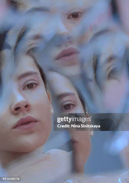 multiple reflection of female face in broken mirror - broken mirror stock-fotos und bilder