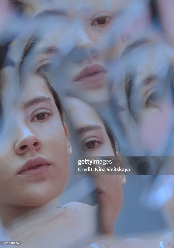 Multiple reflection of female face in broken mirror