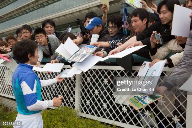 Jockey Norihiro Yokoyama gives his autograph to Japanese racing fans after winning the Osaka Hai at Hanshin Racecourse on April 3, 2016 in...