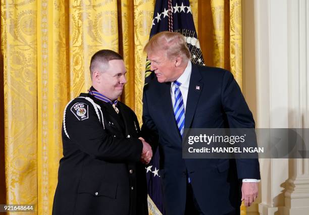 President Donald Trump congratulates Officer Andrew Hopfensperger, Jr., of the Antigo, Wisconsin Police Department, after presenting him with the...