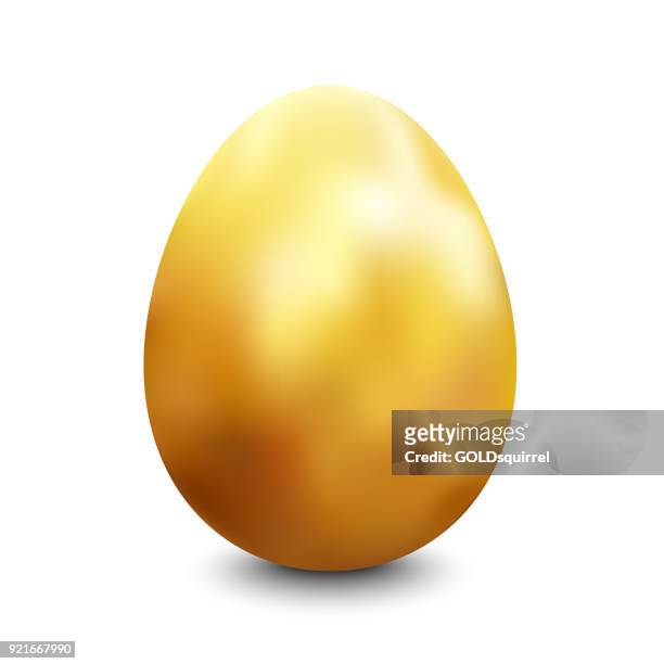 large oval gold painted chicken egg standing vertically on a white surface lit up from the top casting a shadow - easter egg stock illustrations