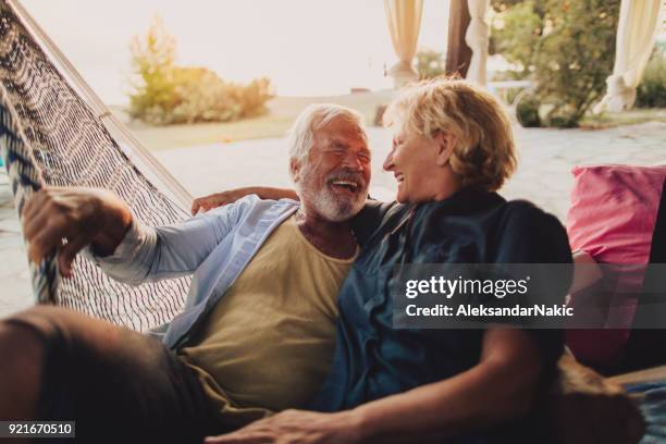 entspannende momente in einer hängematte - old couple on holiday stock-fotos und bilder