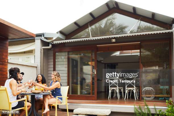 groep vrienden genieten van lunch en barbecue in achtertuin. - australian bbq stockfoto's en -beelden